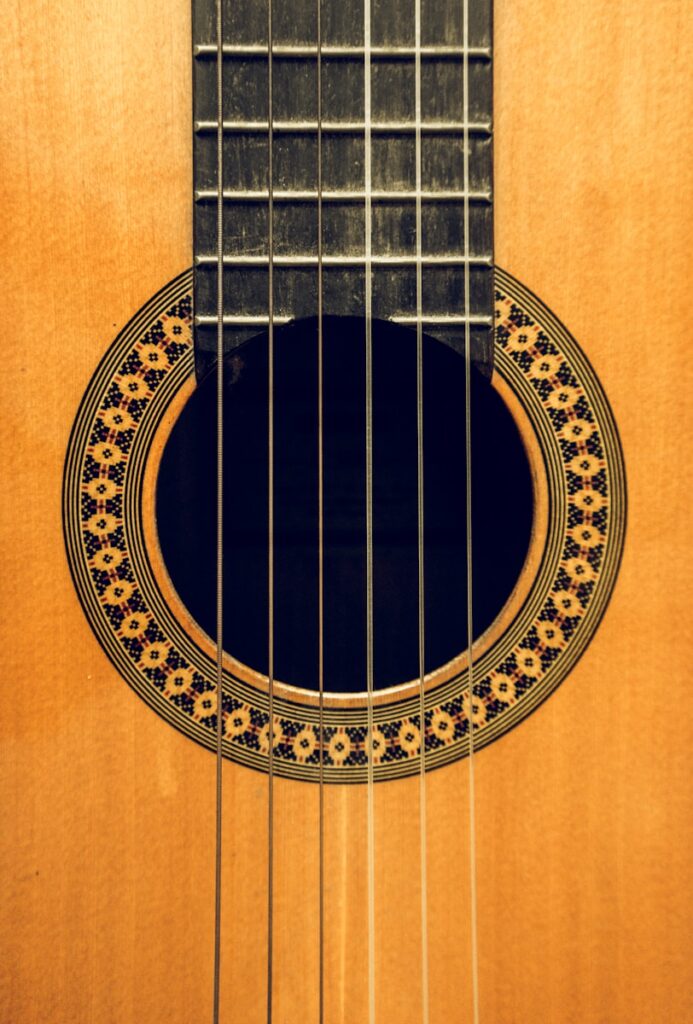 brown acoustic guitar on brown wooden table