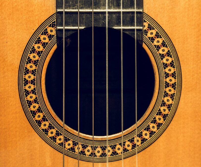 brown acoustic guitar on brown wooden table