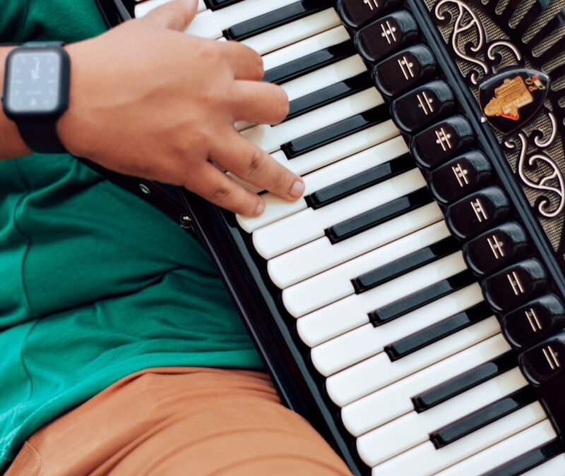 person in green shirt playing piano
