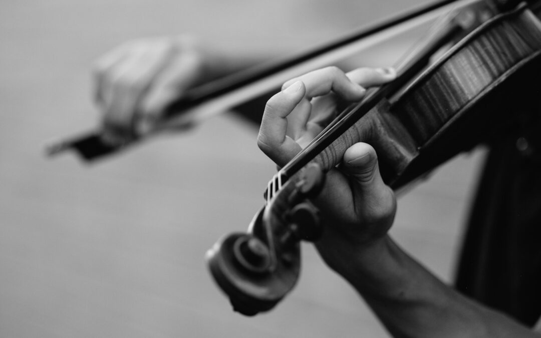 grayscale photo of person playing violin