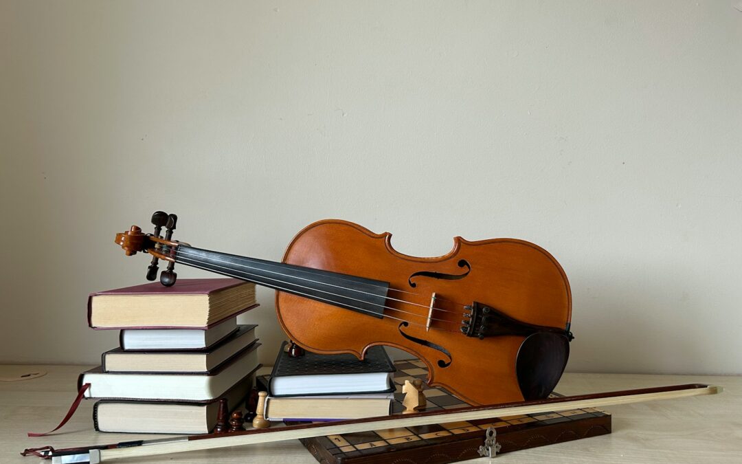 A violin sitting on top of a pile of books